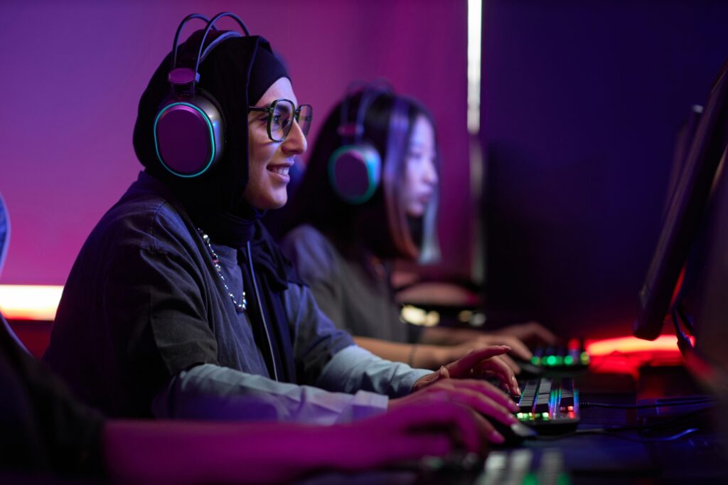 Muslim Woman Playing Video Games in Cybersports Club and Smiling Happily